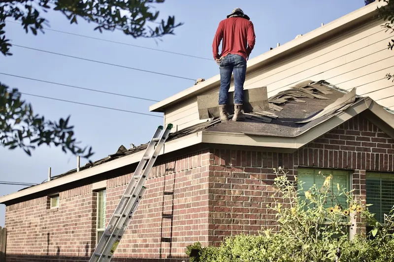 Professional roofer working on a residential roof in Harpers